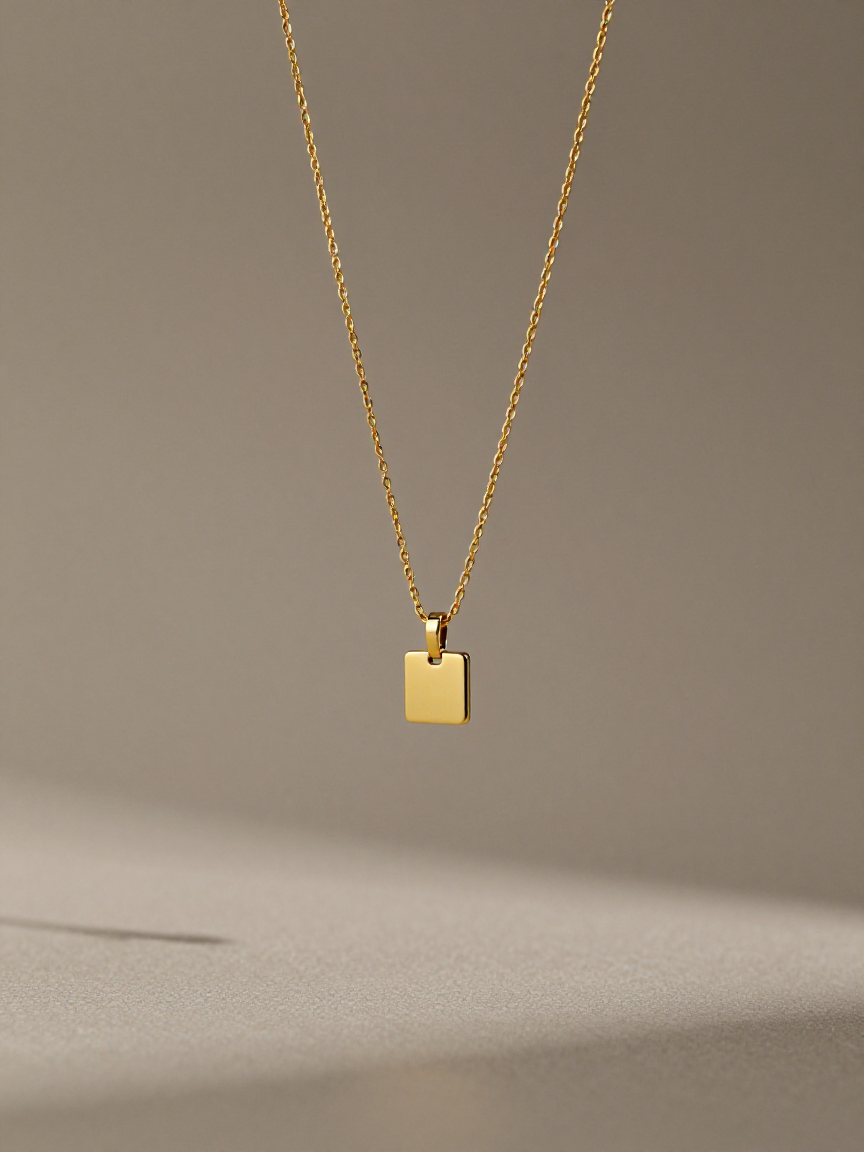 Solid 18k gold pendants and a fine chain laid across warm linen